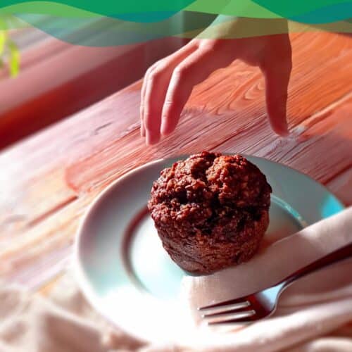 Vegane Schoko-Karotten-Muffins 1 Hand greift nach veganem Schoko-Karotten-Muffin auf Teller