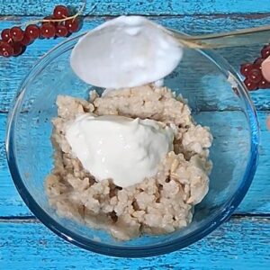 cremiges veganes Porridge Rezept (Haferbrei) auf einem Tisch, joghurt dazu
