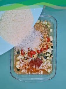 alltagstaugliches rezept für proteinreiches veganes ofengericht mit reis, gemüse, tomaten, zucchini und einem joghurt dip