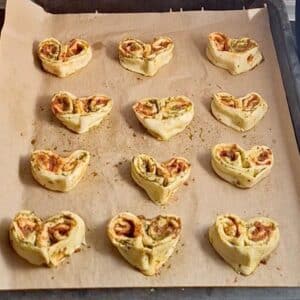 Vegane Pesto-Herzen 17 Vegane Herz-Pesto-Rollen werden auf Blech gelegt