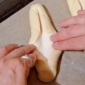 Vegane Laugenstangen mit Tofu-Creme 15 Hände formen Teig auf Backpapier.