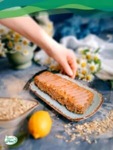 Veganer Zitronenkuchen auf einem Teller mit Haferflocken