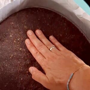 Vegane Himbeertorte 15 Hand drückt auf einen Teig